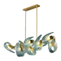 A modern chandelier with a rectangular gold fixture and textured, twisted glass elements in blue. The lamp features gold accents and emits a warm glow, creating an artistic, contemporary appearance.