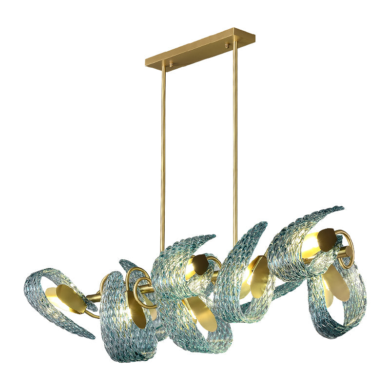 A modern chandelier with a rectangular gold fixture and textured, twisted glass elements in blue. The lamp features gold accents and emits a warm glow, creating an artistic, contemporary appearance.