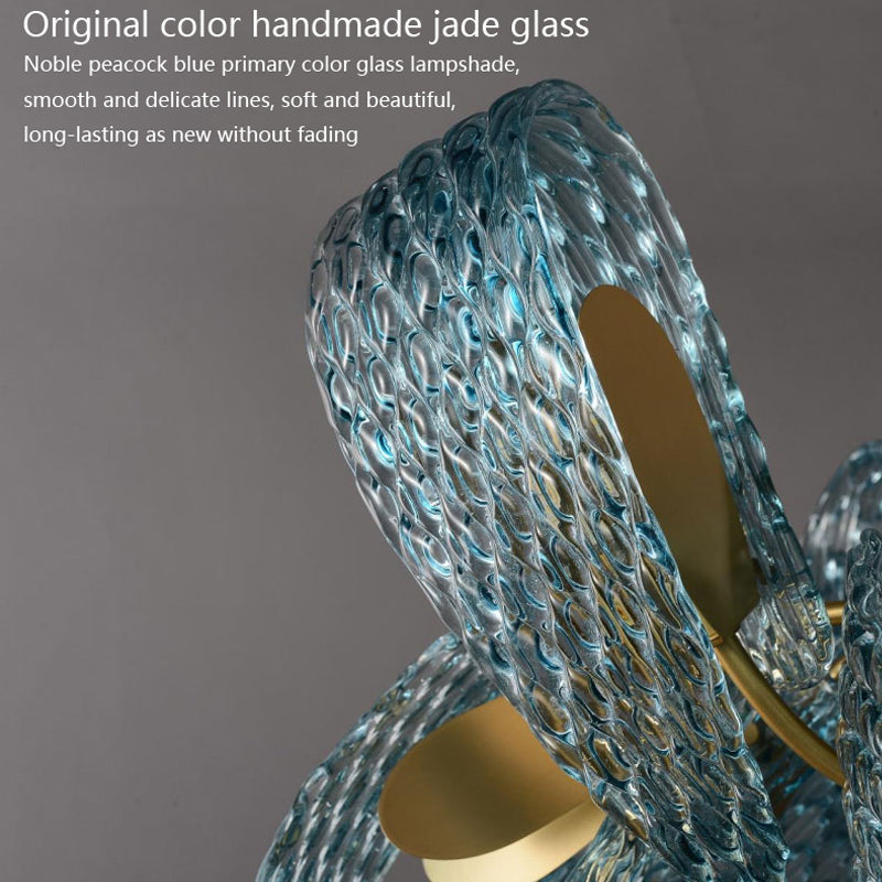 A glass sculpture featuring an elegant design topped with a striking gold ring, showcasing artistry and sophistication.