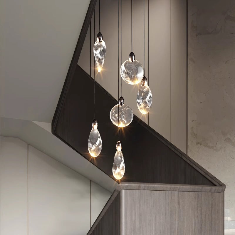 Modern pendant lights over stairwell with grey monochromatic palette.