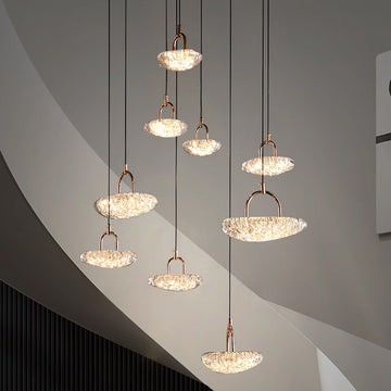 Modern pendant lights with illuminated crystal shades hanging from a ceiling.