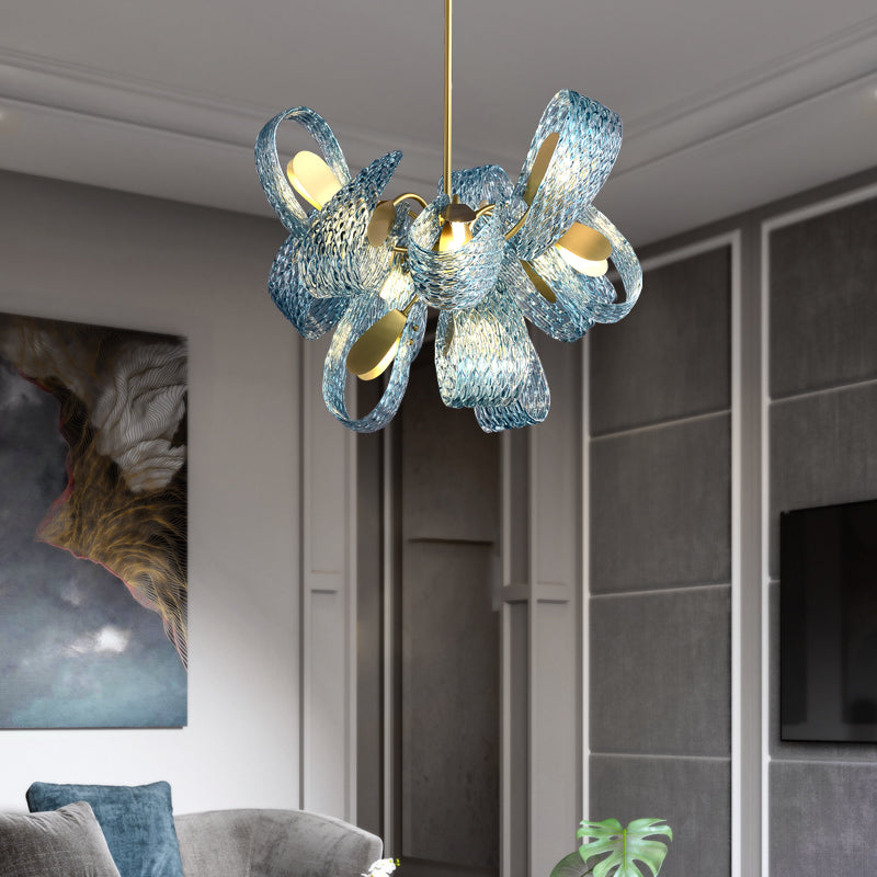 An exquisite blue glass chandelier featuring luxurious gold accents, illuminating the space with style and grace.