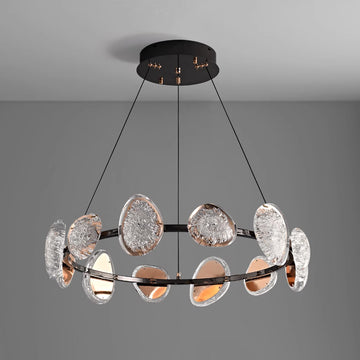 The sleek round chandelier features a black metal frame adorned with textured, translucent oval glass disks and a smart dimming function. Suspended by three thin cables, it enhances any spaces lighting with modern style against a plain gray background.