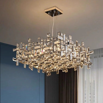 The Luxurious Modern Sparkling Square Crystal Chandelier, with its intricate geometric design and interconnected glass panels featuring LED bulbs, elegantly illuminates a room with blue and white walls.