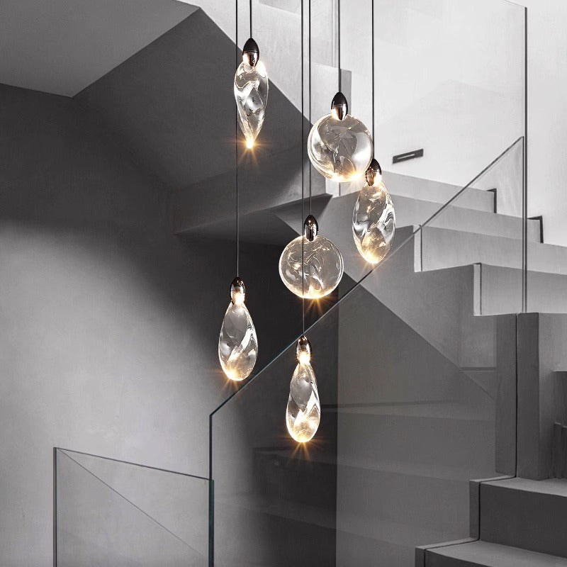 Modern pendant lights over stairwell with grey monochromatic palette.