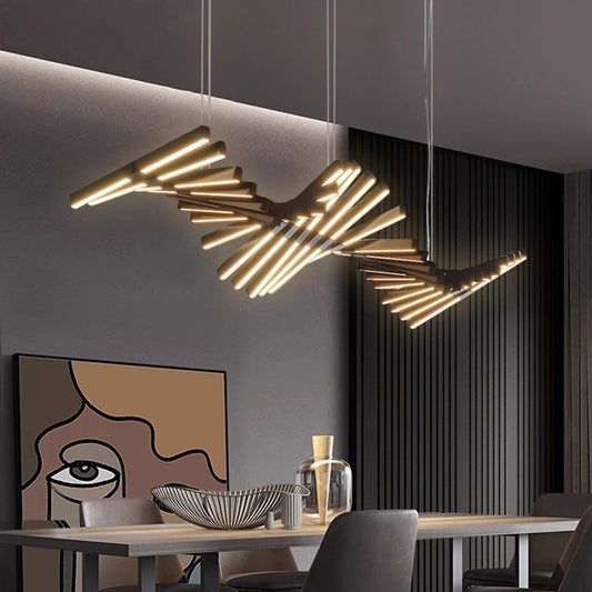 A modern dining room features the Fishbone Wave Chandelier, a unique piece with adjustable glowing horizontal rods. Below it, a table holds decorative items, while abstract face wall art contrasts beautifully against dark vertical paneling.