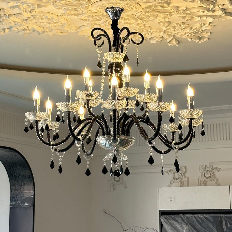 A grand chandelier hangs elegantly in a room, reflecting beautifully in a nearby mirror.
