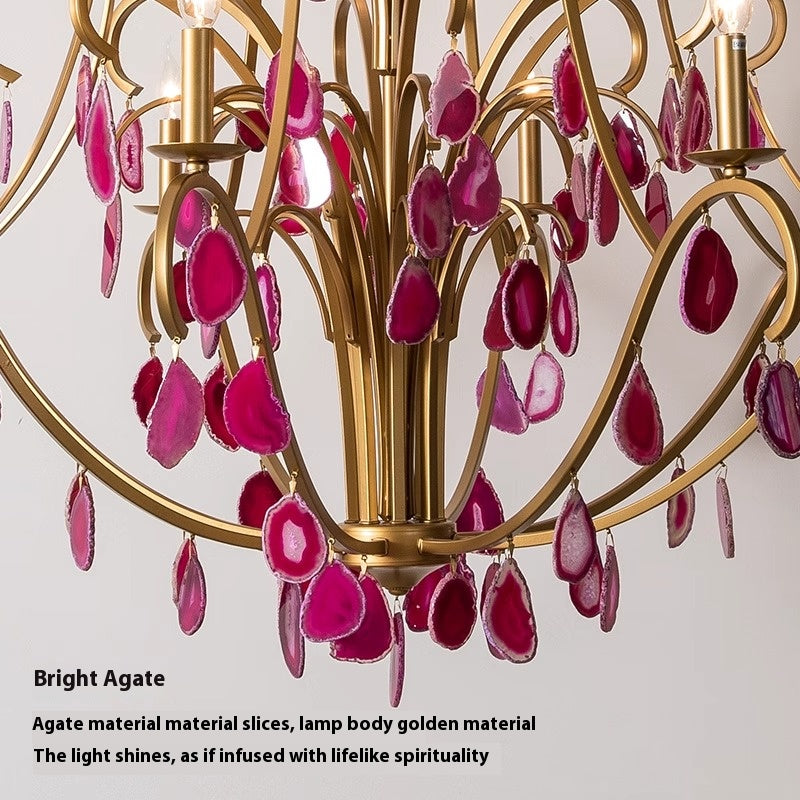 A stunning chandelier adorned with pink stones, elegantly suspended from the ceiling, illuminating the space below.
