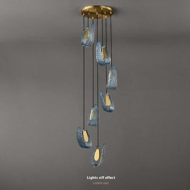 Modern pendant light with six hanging illuminated elements against a grey background.