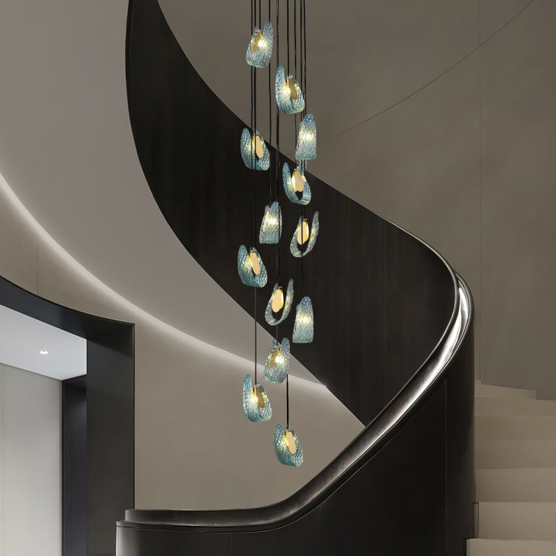 Modern pendant lights hanging over a curved staircase in an elegant interior.