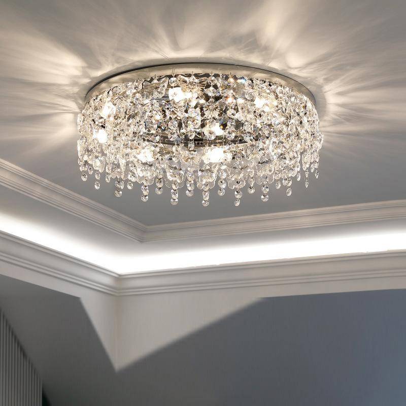 The Butterfly Crystal Ceiling Lamp features a circular design adorned with numerous hanging crystals. It uses an LED bulb to emit a warm glow and intricate patterns on the coffered ceiling. Its DALI dimming function enhances modern interiors with customizable ambiance.