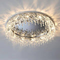 The Butterfly Crystal Ceiling Lamp, with cascading droplets and a metallic base, emits a warm glow. It features an LED bulb and DALI dimming for customizable ambiance while enhancing intricate light patterns on the ceiling.