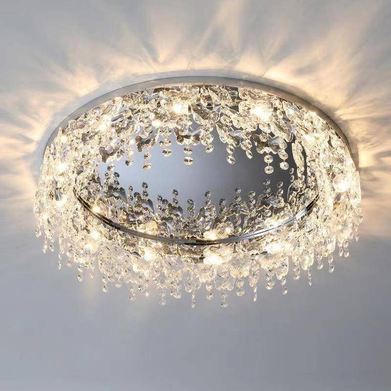 The Butterfly Crystal Ceiling Lamp, with cascading droplets and a metallic base, emits a warm glow. It features an LED bulb and DALI dimming for customizable ambiance while enhancing intricate light patterns on the ceiling.