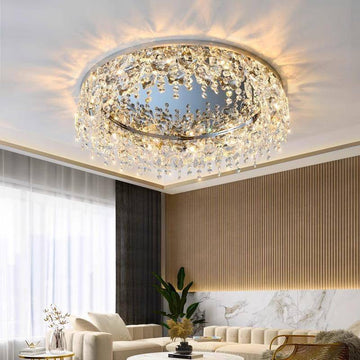 The luxurious living room features the Butterfly Crystal Ceiling Lamp with cascading droplets and an elegant LED glow. Its DALI dimming enhances the ambiance, perfectly complementing a plush sofa, marble accents, and large windows adorned with sheer curtains.