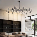 Modern chandelier with multiple rods and lights above a stylish living room interior.