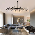 Modern living room with a large gray sectional sofa, unique ceiling light fixture, and open-plan dining area.