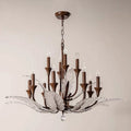 Elegant chandelier with bronze metal accents, candle-style lights, and decorative glass leaves, suspended from a chain.