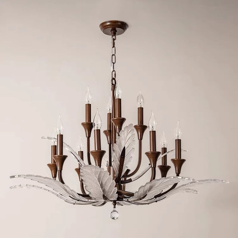 Elegant chandelier with bronze metal accents, candle-style lights, and decorative glass leaves, suspended from a chain.