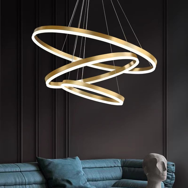 A contemporary pendant light featuring elegant gold rings, adding a touch of sophistication to any space.