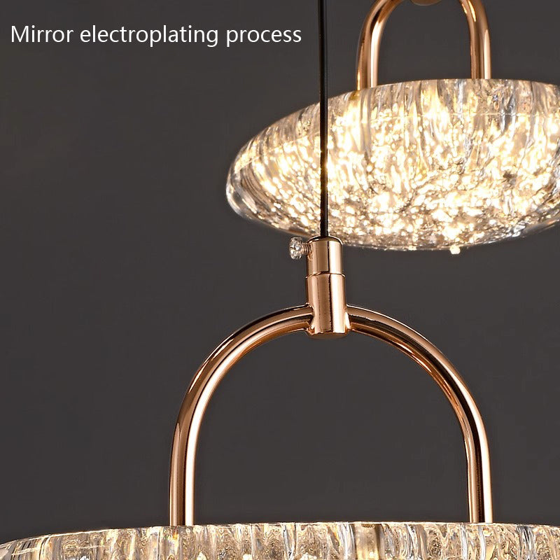 Close-up of a glowing chandelier with a textured glass shade and gold finish.