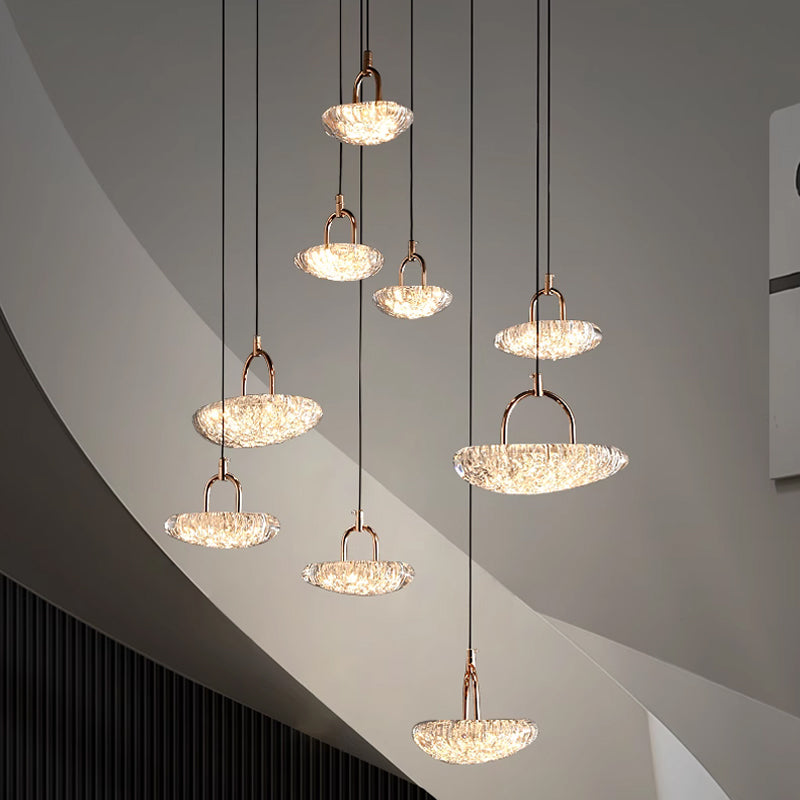 Modern pendant lights with illuminated crystal shades hanging from a ceiling.