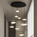 Modern pendant lights hanging from a ceiling in a room with neutral tones.