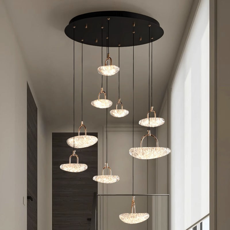 Modern pendant lights hanging from a ceiling in a room with neutral tones.