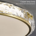 Close-up of a brass lamp body with textured glass edge and illuminated frosted lampshade.