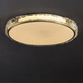 Circular ceiling light fixture with a gold rim on a dark background.