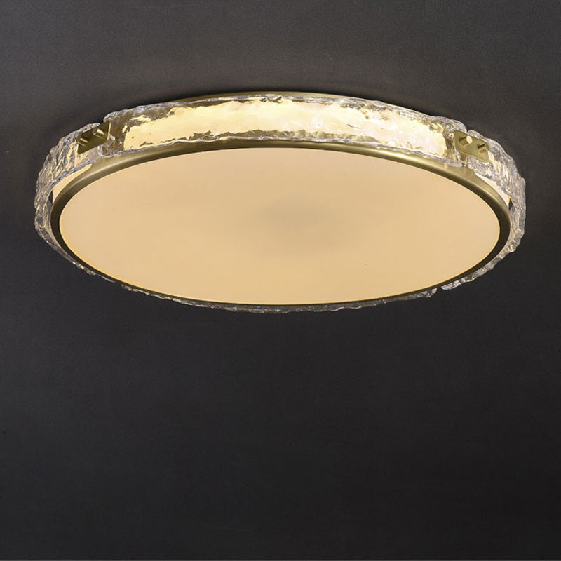Circular ceiling light fixture with a gold rim on a dark background.