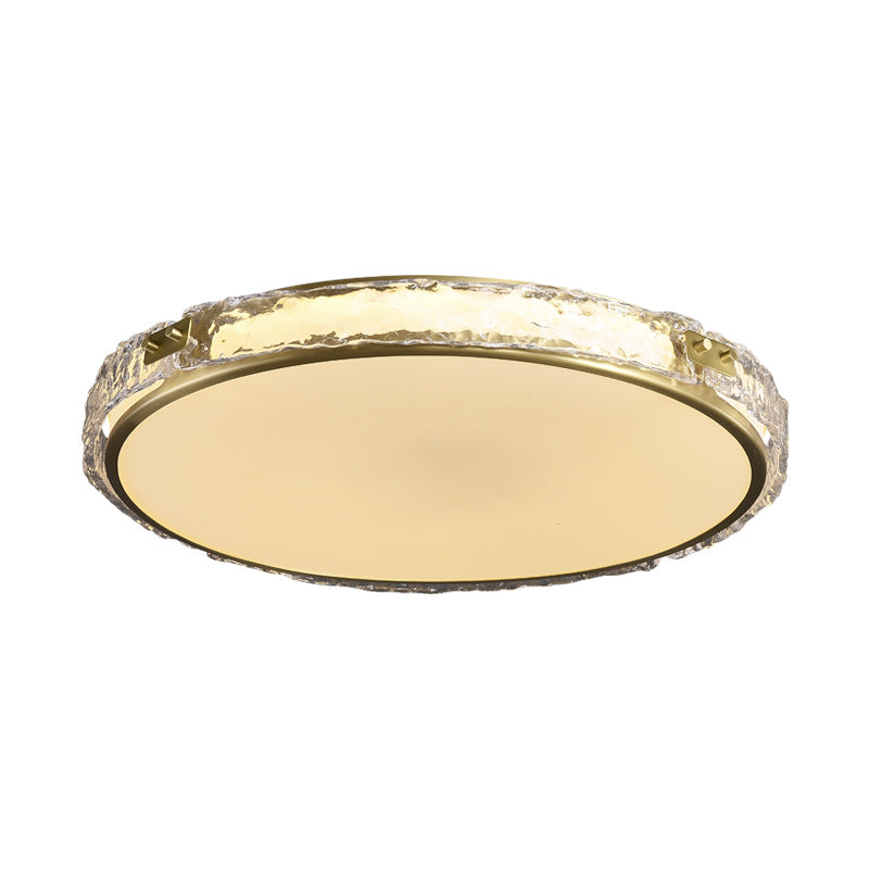 Round ceiling light fixture with a textured gold rim and opaque diffuser.
