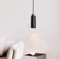 In this minimalist space, a dimmable LED bulb emits a warm glow from the Travertine Restaurant Chandelier, illuminating a sleek black side table with its white bowl. A touch of light grey sofa contrasts with the pure white wall, enhancing the serene ambiance.