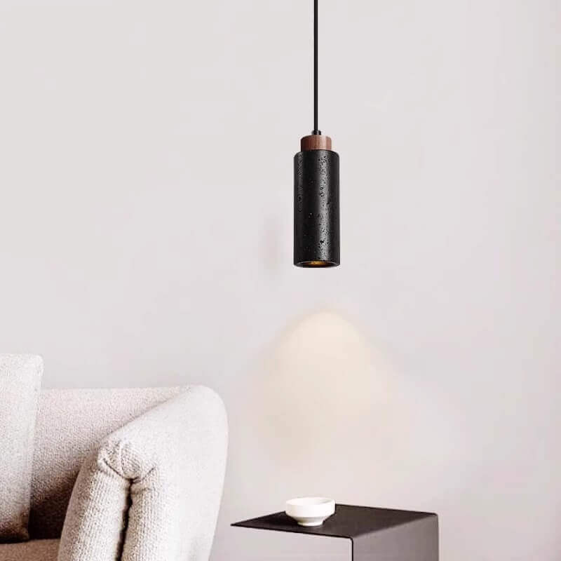 In this minimalist space, a dimmable LED bulb emits a warm glow from the Travertine Restaurant Chandelier, illuminating a sleek black side table with its white bowl. A touch of light grey sofa contrasts with the pure white wall, enhancing the serene ambiance.