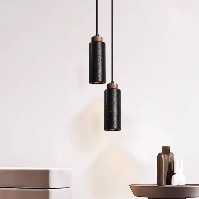 A Travertine Restaurant Chandelier with dimmable LED bulbs hangs from the ceiling. Below, a table showcases a brown decorative bottle and a small white sculpture, all framed by a minimalist beige wall, epitomizing modern minimalist interiors.