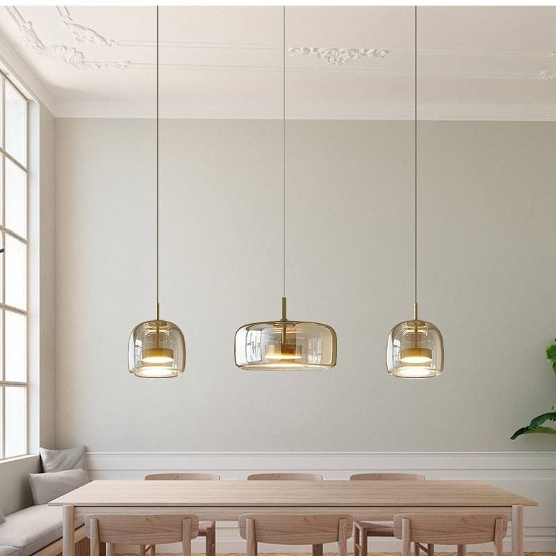 Bright dining room showcasing a Retro Chandelier with adjustable hanging wires above a long wooden table surrounded by chairs. Large windows on the left bring in natural light, illuminating the minimalist space with light-colored walls and ceiling moldings.