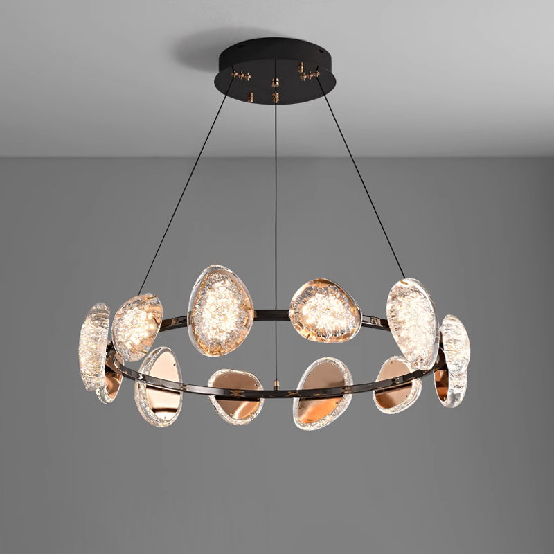 This round chandelier, with a sleek black frame and suspended by four cords, features textured oval-shaped reflective glass elements. Its warm glow enhances any room, while the smart dimming function offers customizable ambiance against a plain gray background.