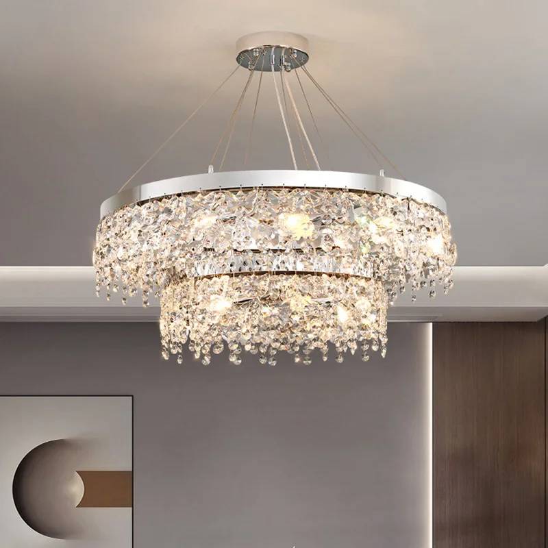 The Crystal Butterfly Chandelier features two circular tiers adorned with sparkling K9 crystal droplets and a modern metal frame, offering a warm glow as it luxuriously hangs from the ceiling.