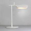 The Simple Desktop Lamp features a modern white design with a horizontal LED fixture, round base, and slim stand. It emits a soft, warm light that creates a subtle glow against a plain gray background.