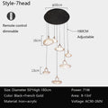 A 3-headed pendant light with remote control, black and gold colors, iron and acrylic materials, and adjustable height.
