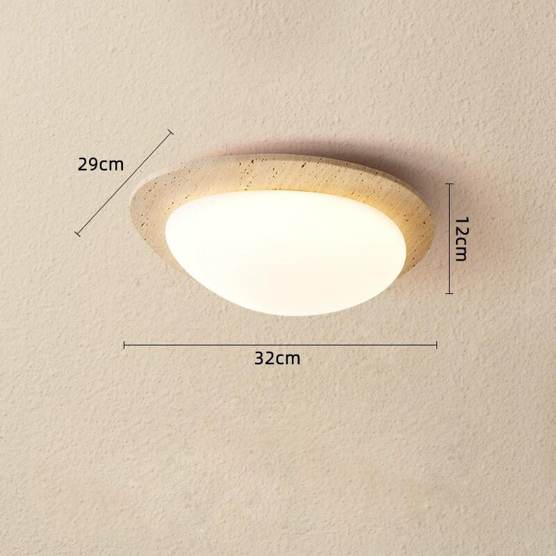 The Wabi-Sabi Travertine LED Ceiling Light, featuring a wooden rim and white diffuser in modern style, is mounted on a beige wall. Dimensions: 29 cm height, 32 cm width, 12 cm depth.