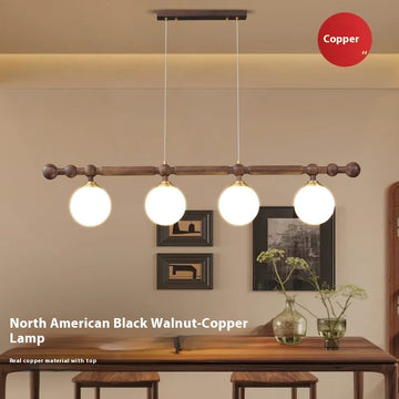 A wooden horizontal bar with four spherical pendant lights hanging over a table, with a "Copper" label in the background.