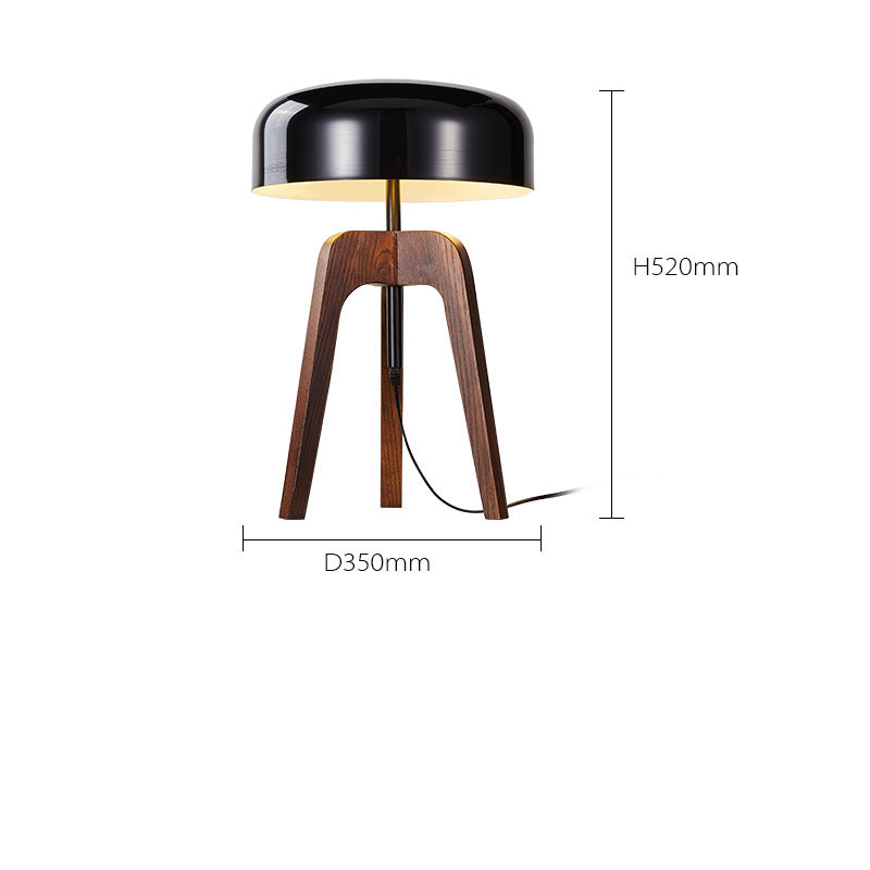 The Tripod Floor Lamp is a modern piece with a black dome-shaped wood metal shade and wooden tripod base, standing 520mm tall with a 350mm diameter. Its minimalist design features an LED bulb and cable extending from the base.