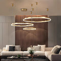 Modern living room with beige sectional sofa, green and gray cushions, wooden accent wall, and three circular pendant lights.