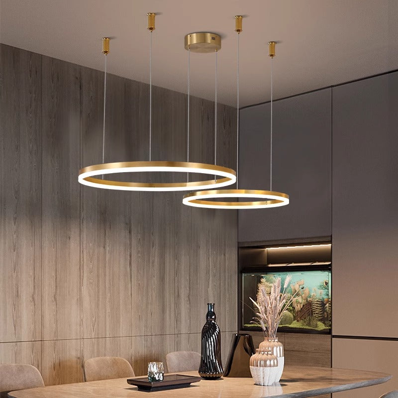 Modern circular pendant lights above a sleek dining table in a contemporary room.