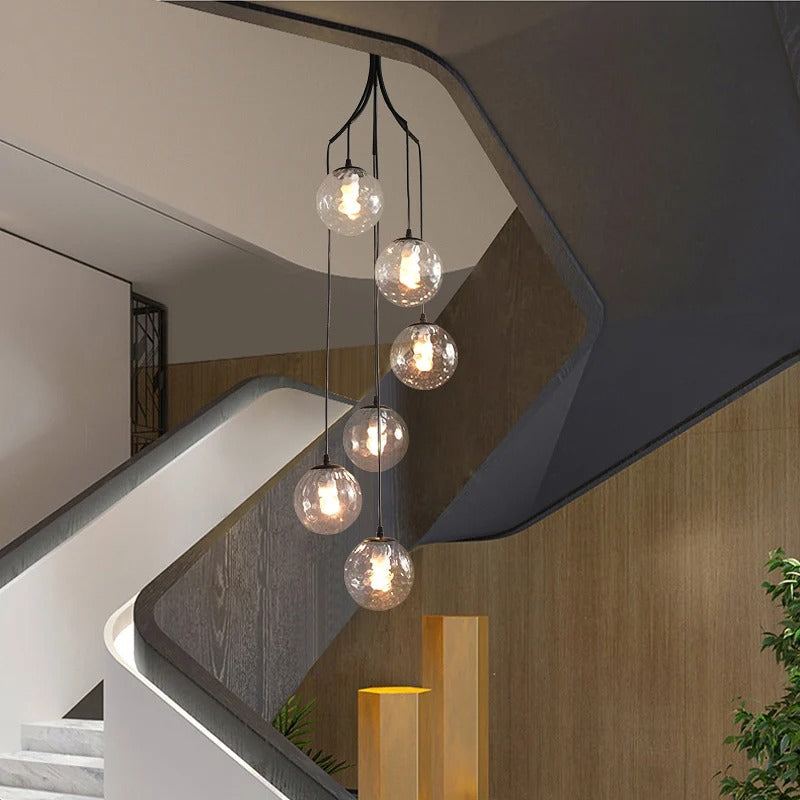 A sleek staircase complemented by an exquisite gold and white chandelier, adding a touch of elegance to the space.
