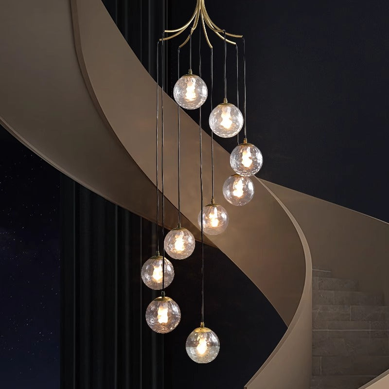 A stylish modern staircase adorned with a stunning gold and white chandelier, creating a sophisticated atmosphere.