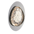 The oval-shaped silver wall sconce features a textured transparent glass center, emitting a warm glow with energy-efficient LED technology and smart dimming capabilities; great wall lamps for bedroom ambiance.