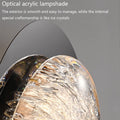 Close-up of modern wall lamps for bedrooms with an optical acrylic lampshade featuring a smooth exterior and ice crystal-like interior. Equipped with energy-efficient LED technology, their craftsmanship stands out against a plain gray background.