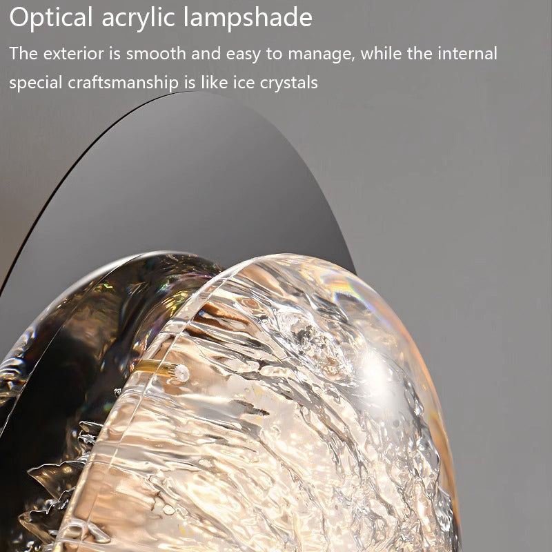 Close-up of modern wall lamps for bedrooms with an optical acrylic lampshade featuring a smooth exterior and ice crystal-like interior. Equipped with energy-efficient LED technology, their craftsmanship stands out against a plain gray background.
